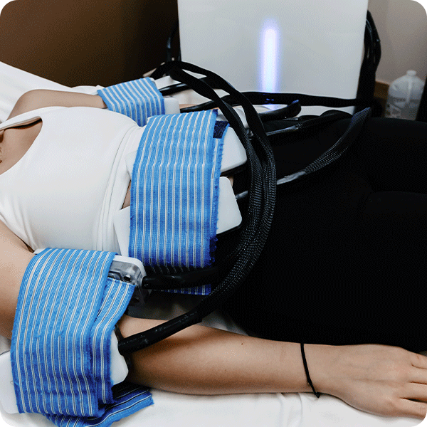 Female patient laying down with cryotherapy bands on arms and stomach