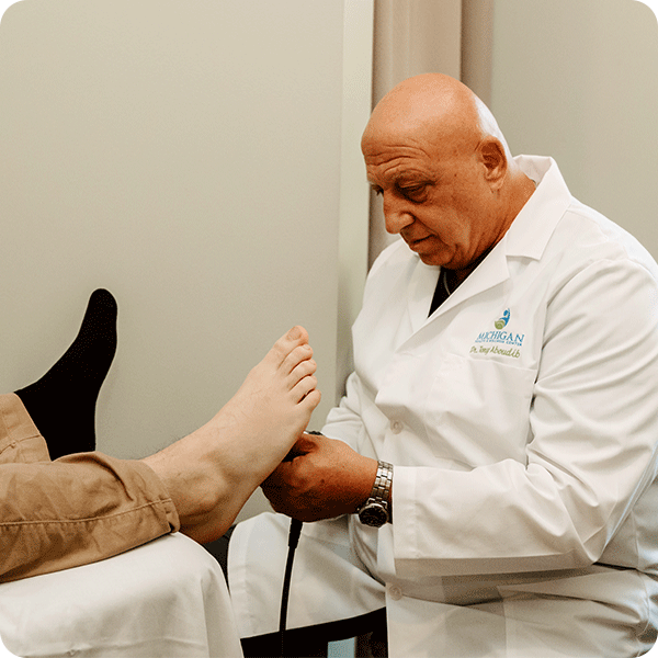 Doctor Tony adjusts the bottom of a patient's foot to alleviate pain