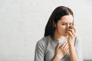 Woman using an inhaler for asthma